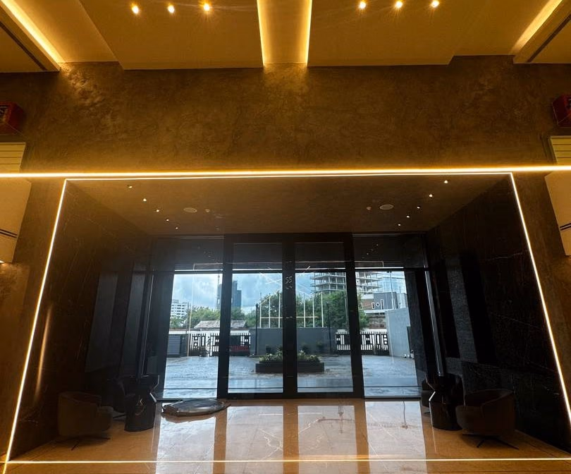 Lobby with a lit ceiling cove and glazed entrance