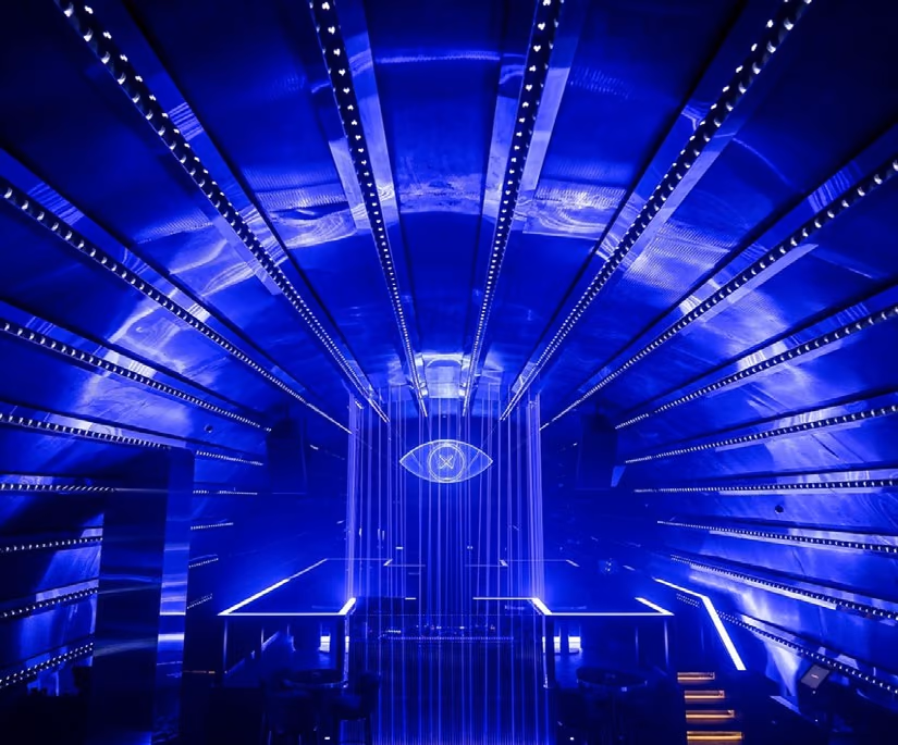 The club room lit blue, with light lines radiating across the ceiling