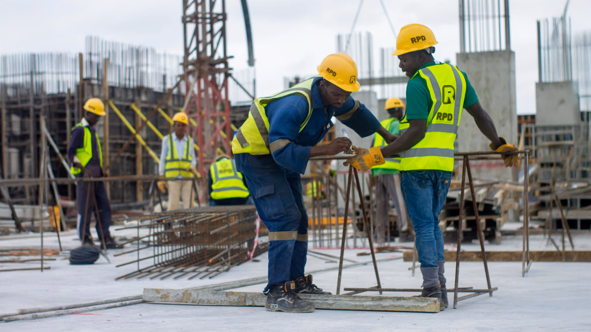 RPD crew in hard hats and high-visibility vests fixing reinforcement on a slab
