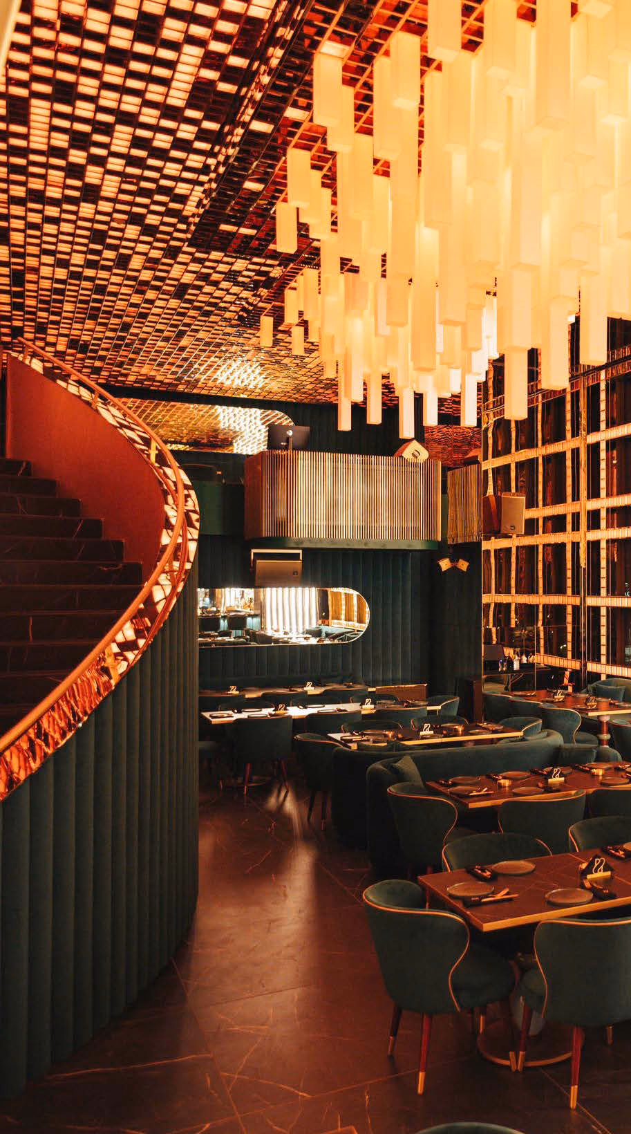 Restaurant with a red curved stair and a ceiling of hanging lights